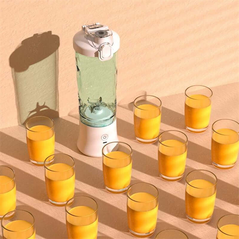 Mini Blender surrounded by filled glasses of juice on a countertop, showcasing its design and functionality.